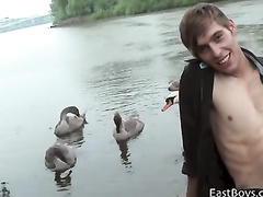 Sexy handsome gay is pleasuring hot handjob by the lake
